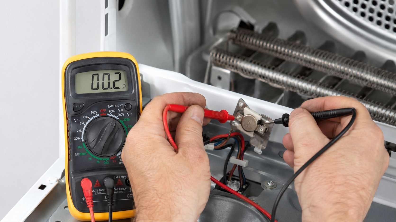 A technician uses a digital multimeter to test continuity on a dryer thermal fuse element.
